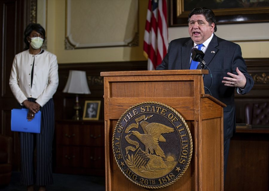 Gov. J.B. Pritzker answers questions from the media, along with Dr. Ngozi Ezike, left, director of the Illinois Department of Public Health, during his daily press briefing on the COVID-19 pandemic from his office Friday at the Illinois State Capitol in Springfield.