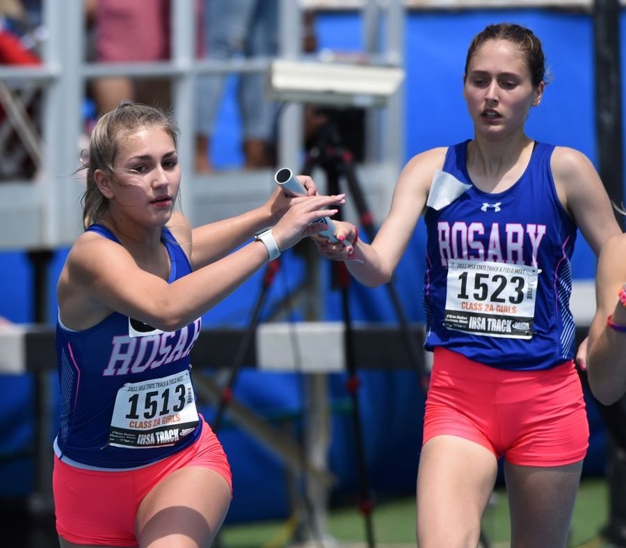 Rosary's Lilly Caruso, front, takes the baton from teammate Lianna Surtz in the 1,600-meter relay during the Class 2A girls state track preliminaries at Eastern Illinois University in Charleston Friday.