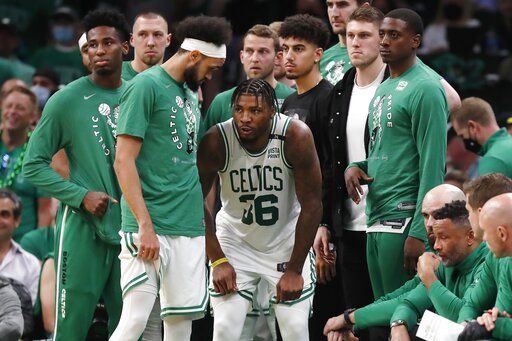 Boston Celtics' Marcus Smart come back on the court after leaving temporarily with an injury during the second half of Game 3 of the team's NBA basketball playoffs Eastern Conference finals against the Miami Heat, Saturday, May 21, 2022, in Boston.