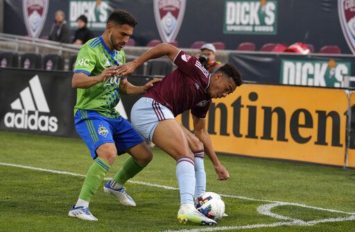 Seattle Sounders midfielder Cristian Roldan, left, fights for control of the ball with Colorado Rapids forward Jonathan Lewis in the second half of an MLS soccer match Sunday, May 22 2022, in Commerce City, Colo.
