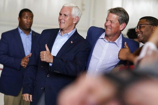 Former Vice President Mike Pence, second from left, and Georgia Gov. Brian Kemp, center, pose for a photo with a supporter after a Get Out the Vote Rally,  on the eve of gubernatorial and other primaries in the state, on Monday, May 23, 2022, in Kennesaw, Ga.