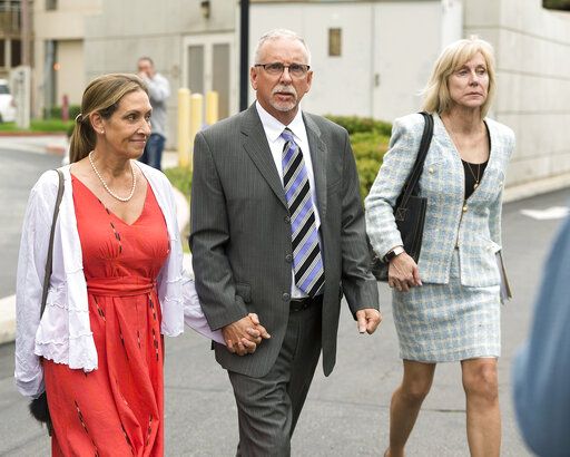 FILE - Former UCLA gynecologist Dr. James Heaps, center, with his wife Deborah, left, and defense attorney Tracy Green leave Los Angeles Superior Court, on June 26, 2019. A lawsuit alleging that the former UCLA gynecologist sexually abused hundreds of women has been settled for $246.3 million. The amount of the settlement was announced Tuesday, Feb. 8, 2022, by UCLA and some of the lawyers representing 203 women. It's one of hundreds of lawsuits filed by patients who allege that Dr. Heaps groped or otherwise abused them during his 35-year career.