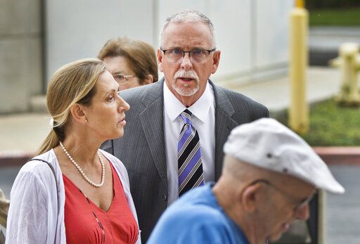 FILE - In this June 26, 2019 file photo UCLA gynecologist James Heaps, center, and his wife, Deborah Heaps, arrive at Los Angeles Superior Court. The University of California has agreed to pay more than $100 million to settle allegations that several hundred women were sexually abused by Heaps.