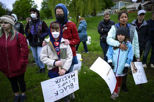 Community members bow their heads in a moment of silence during a vigil at the 'Say Their Names' cemetery Wednesday, May 25, 2022, in Minneapolis. The intersection where George Floyd died at the hands of Minneapolis police officers was renamed in his honor Wednesday, among a series of events to remember a man whose killing forced America to confront racial injustice. (Aaron Lavinsky/Star Tribune via AP)
