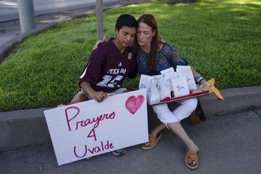Diego Esquivel, left, and Linda Klaasson comfort each other as they gather to honor the victims killed in Tuesday's shooting at Robb Elementary School in Uvalde, Texas, Wednesday, May 25, 2022. Desperation turned to heart-wrenching sorrow for families of grade schoolers killed after an 18-year-old gunman barricaded himself in their Texas classroom and began shooting, killing multiple grade schoolers and their two teachers.