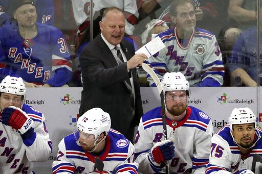 New York Rangers head coach Gerard Gallant, center top, directs the team against the Carolina Hurricanes during the first period in Game 2 of an NHL hockey Stanley Cup second-round playoff series Friday, May 20, 2022, in Raleigh, N.C.