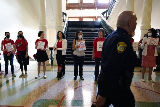 Women with Moms Demand Action gather outside the Texas Senate Chamber as the second day of a hearing begins, Wednesday, June 22, 2022, in Austin, Texas. The hearing is in response to the recent school shooting in Uvalde, Texas, where two teachers and 19 students were killed.