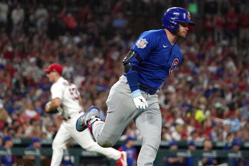Chicago Cubs' Ian Happ, right, rounds first on his way to an RBI double off St. Louis Cardinals starting pitcher Andre Pallante, left, during the fifth inning of a baseball game Friday, June 24, 2022, in St. Louis.