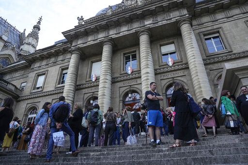 Lawyers and trial goers gather outside the court house after the verdict in Paris Wednesday, June 29, 2022. The lone survivor of a team of Islamic State extremists was convicted Wednesday of murder and other charges and sentenced to life in prison without parole in the 2015 bombings and shootings across Paris that killed 130 people in the deadliest peacetime attacks in French history.
