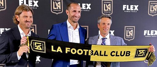 Agent Davide Lippi, left; Giorgio Chiellini, center; and Los Angeles FC co-president/general manager John Thorrington pose for a photo in Los Angeles on Wednesday, June 29, 2022. Chiellini is coming to the United States and Major League Soccer following 15 years with Juventus in Italy's Serie A.