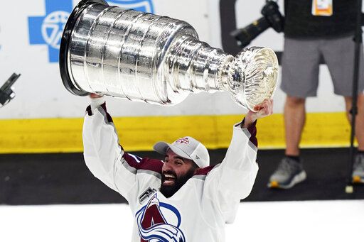 CORRECTS ID TO NAZEM KADRI INSTEAD OF NATHAN MACKINNON - Colorado Avalanche center Nazem Kadri lifts the Stanley Cup after the team defeated the Tampa Bay Lightning 2-1 in Game 6 of the NHL hockey Stanley Cup Finals on Sunday, June 26, 2022, in Tampa, Fla.
