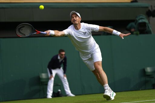 Britain's Andy Murray returns the ball to John Isner of the US during their singles tennis match on day three of the Wimbledon tennis championships in London, Wednesday, June 29, 2022.