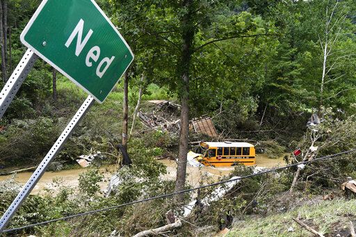 A Perry County school bus lies destroyed after being caught up in the floodwaters of Lost Cree in Ned, Ky., Friday, July 29, 2022.