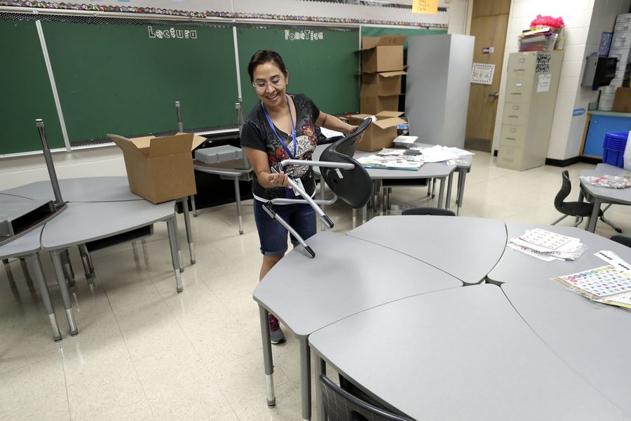 First-grade teacher Maria Elisa Chaidez prepares her classroom Thursday for the return of students at Laurel Hill Elementary School in Hanover Park. COVID restrictions have eased with no requirements for social distancing or masking in schools.