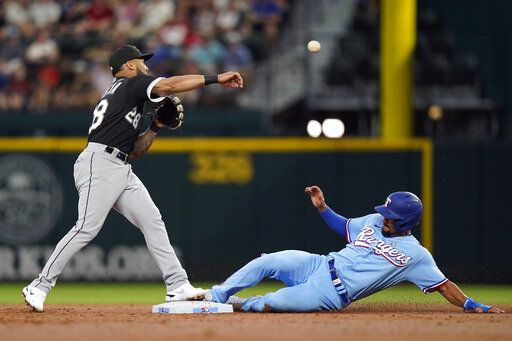 Chicago White Sox second baseman Leury Garcia (28) throws to first base to get out Texas Rangers' Corey Seager for a double play over Rangers' Marcus Semien, right, during the first inning of a baseball game in Arlington, Texas, Sunday, Aug. 7, 2022.