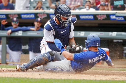 Minnesota Twins catcher Gary Sanchez tags out Toronto Blue Jays' Whit Merrifield who tags from third on a sacrifice fly by Cavan Biggio in the tenth inning of a baseball game Sunday, Aug. 7, 2022, in Minneapolis. The play was overturned on review due to the catcher blocking the plate and the Blue Jays won 3-2 in 10.