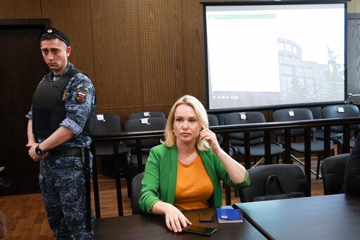 FILE - Marina Ovsyannikova, a former Russian state TV journalist who quit after making an on-air protest of Russia's military operation in Ukraine, sits in a court room prior to a hearing in Moscow, Russia, Thursday, July 28, 2022. Russian authorities on Wednesday raided the home of a former state TV journalist who quit after making an on-air protest against Moscow's special military operation in Ukraine. The case against Marina Ovsyannikova was launched under a law that penalizes statements against the military.