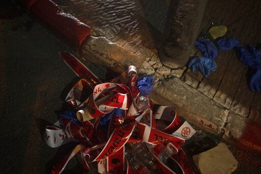 Police tape and gloves are discarded at the scene of a shooting attack that wounded several Israelis near the Old City of Jerusalem, early Sunday, Aug. 14, 2022. Israeli police and medics say a gunman opened fire at a bus in a suspected Palestinian attack that came a week after violence flared up between Israel and militants in Gaza.