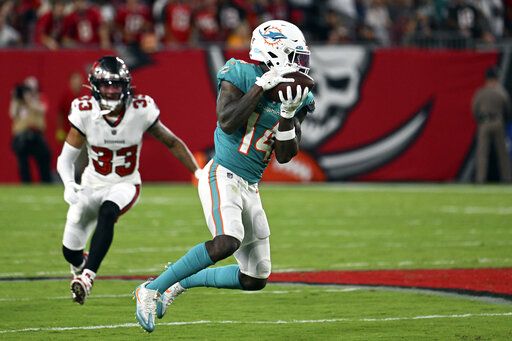 Miami Dolphins wide receiver Trent Sherfield (14) makes a catch in front of Tampa Bay Buccaneers safety Troy Warner (33) during the first half of an NFL preseason football game Saturday, Aug. 13, 2022, in Tampa, Fla.