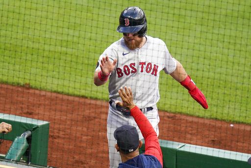 Boston Red Sox's Christian Arroyo, top, is greeted as he returns to the dugout after scoring on a hit by Like Hernandez during the second inning of a baseball game Wednesday, Aug. 17, 2022, in Pittsburgh.