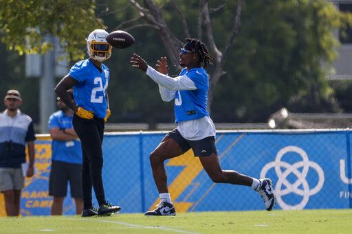 Los Angeles Chargers safeties Derwin James Jr., right, throws a ball as Nasir Adderley (24) looks on during the NFL football team's training camp, Wednesday, July 27, 2022, in Costa Mesa, Calif.
