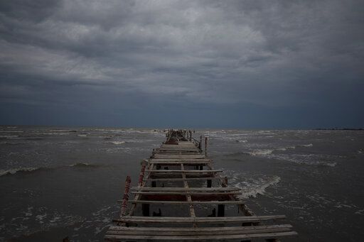 FILE - Waves kick up under a dark sky along the shore of Batabano, Cuba, Sept. 26, 2022. Hurricane Ian is quickly gaining monstrous strength as it moves over oceans partly heated up by climate change.