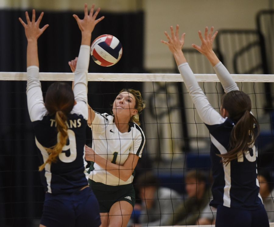 Glenbrook North's Austyn Davis, middle, tries to get the ball past Glenbrook South's Bella Pehar, left, and Kendall Hackett during Tuesday's volleyball match in Glenview.