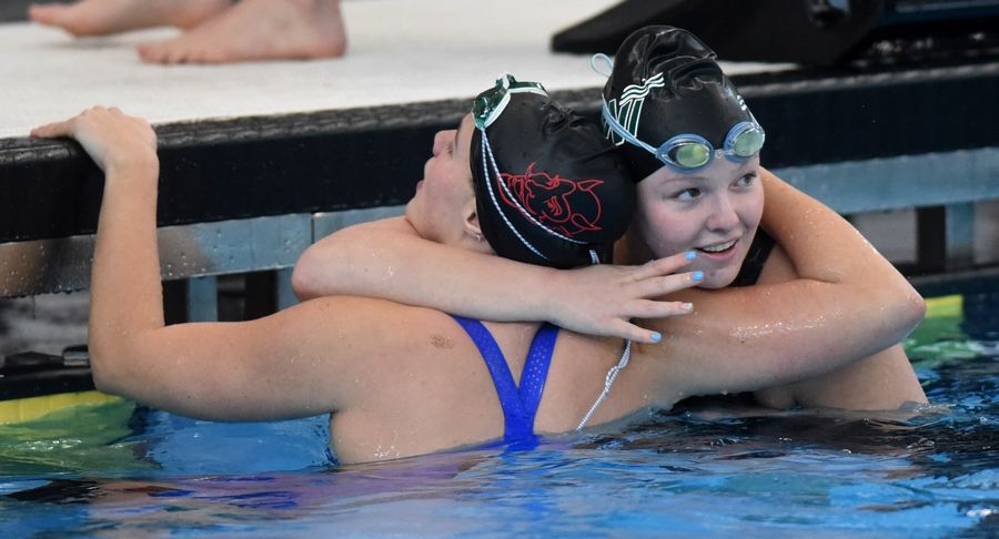 New Trier's Megan Marquardt, right, hugs Phoebe Paarllberg of Hinsdale Central at the conclusion of the 200-yard medley relay during the IHSA girls state swimming finals at FMC Natatorium in Westmont on Saturday, Nov. 12, 2022.