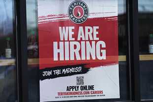 A hiring sign is displayed at a restaurant in Rolling Meadows. America’s employers added a robust 517,000 jobs in January, a surprisingly strong gain in the face of the Federal Reserve’s aggressive drive to slow growth and tame inflation with higher interest rates.