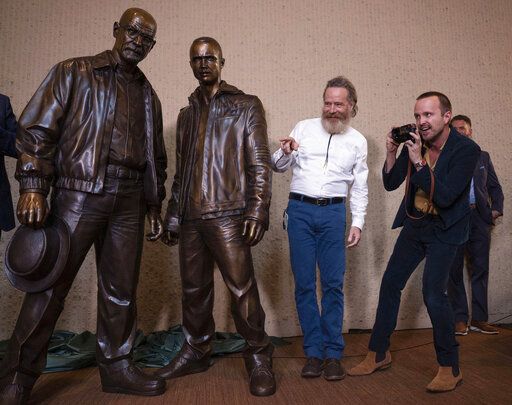 Bryan Cranston, left, and Aaron Paul view statues of their characters during the "Breaking Bad" unveiling event in downtown Albuquerque, N.M., on Friday July 29, 2022. (Chancey Bush/The Albuquerque Journal via AP)